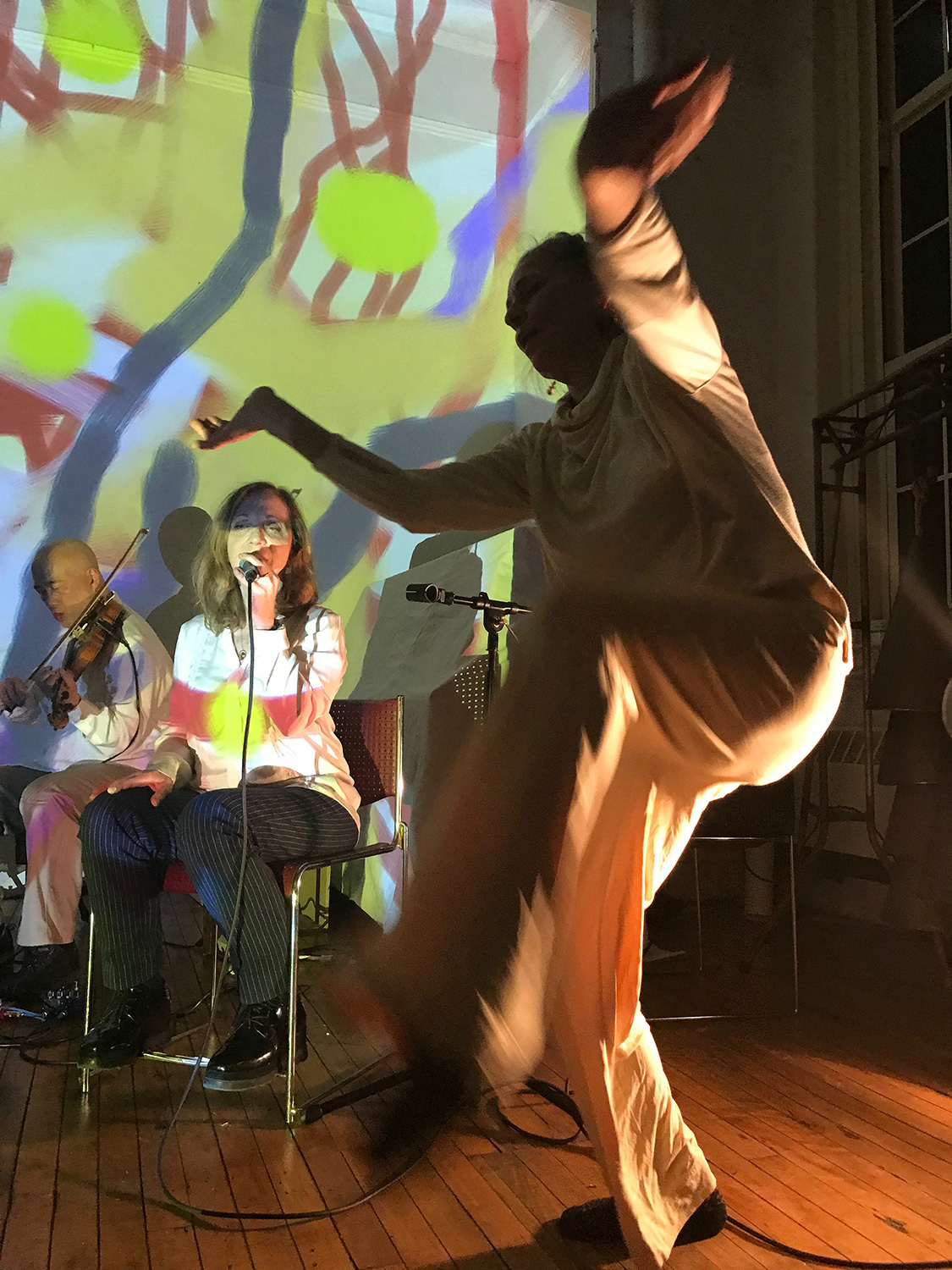 patricia nicholson dances in front of a colorfully painted wall